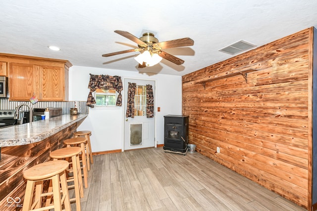 kitchen with light wood-type flooring, ceiling fan, and a textured ceiling