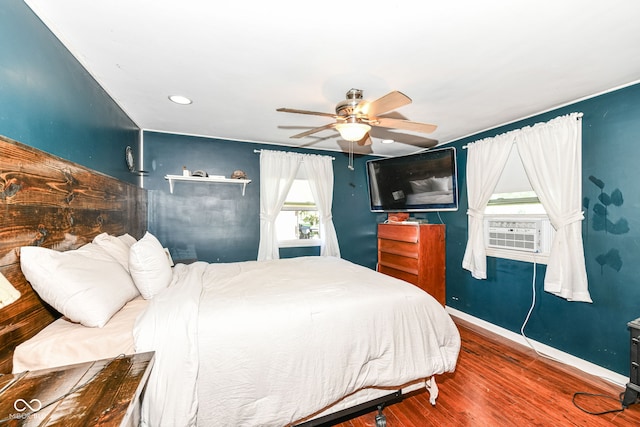 bedroom featuring cooling unit, hardwood / wood-style floors, and ceiling fan