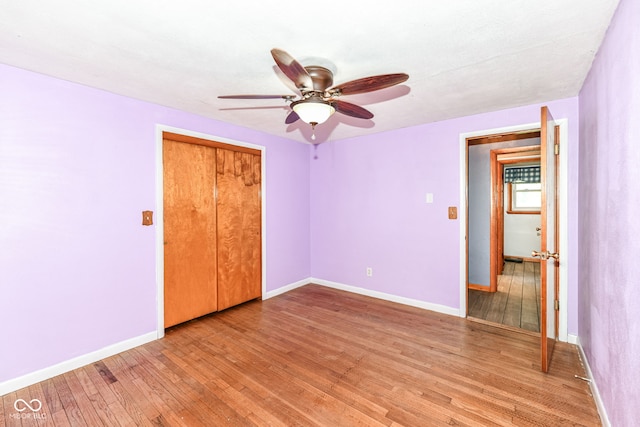 unfurnished bedroom with light hardwood / wood-style flooring, a closet, and ceiling fan