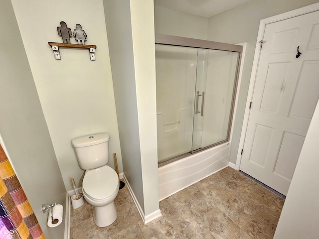 bathroom featuring enclosed tub / shower combo and toilet