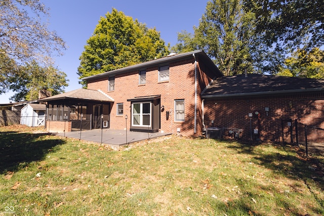 rear view of property featuring a patio, a sunroom, and a yard