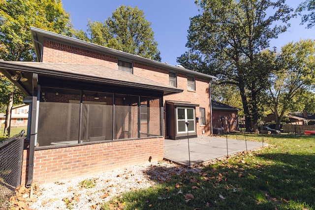 back of house featuring a sunroom, cooling unit, a patio area, and a lawn