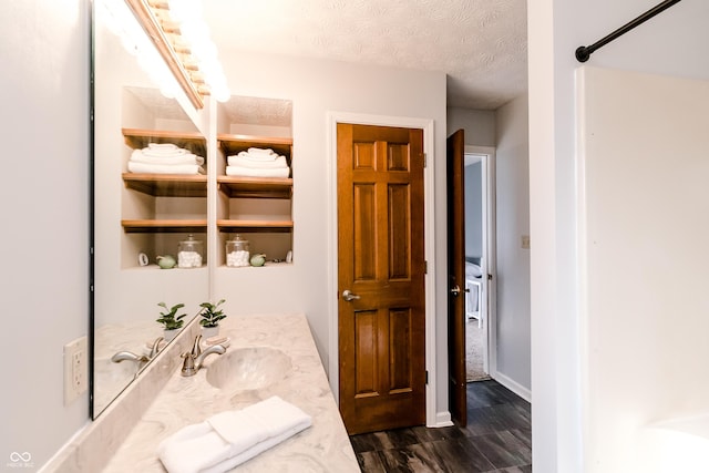 bathroom with vanity, hardwood / wood-style floors, and a textured ceiling