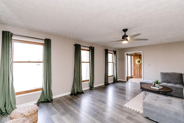 unfurnished living room featuring ceiling fan, dark hardwood / wood-style flooring, and a textured ceiling