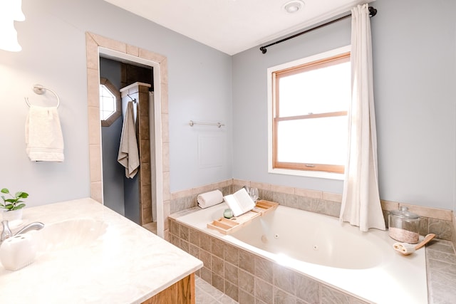 bathroom with vanity, plenty of natural light, and tiled bath