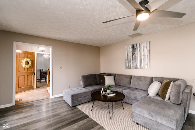 living room with hardwood / wood-style flooring, ceiling fan, and a textured ceiling