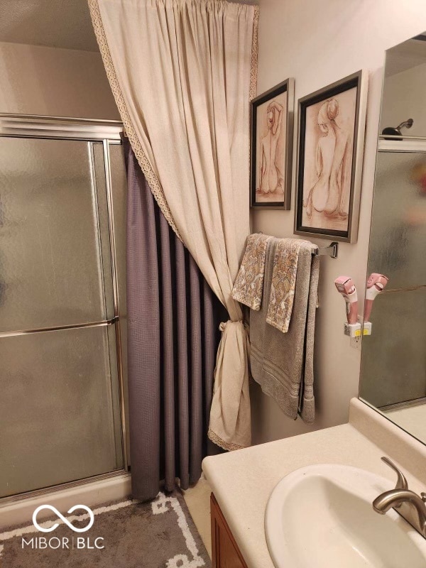 bathroom featuring vanity and a shower with shower door