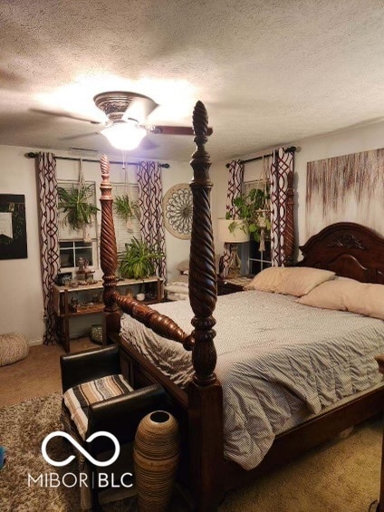 carpeted bedroom with ceiling fan and a textured ceiling