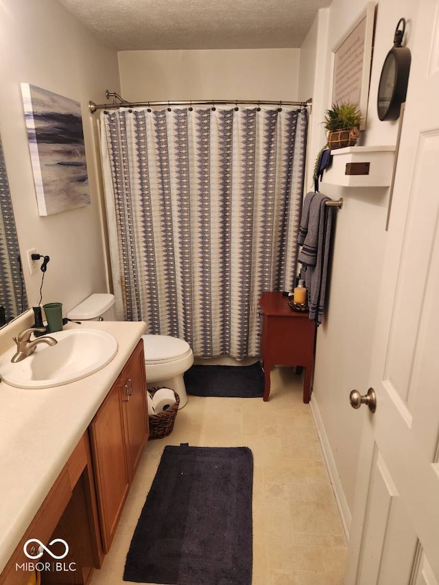 bathroom with vanity, a textured ceiling, and toilet