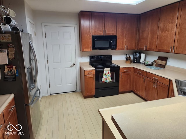 kitchen with sink, light hardwood / wood-style flooring, and black appliances