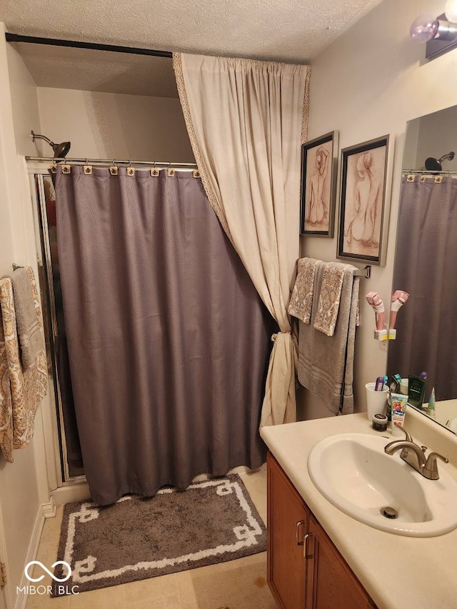 bathroom with a shower with curtain, vanity, and a textured ceiling