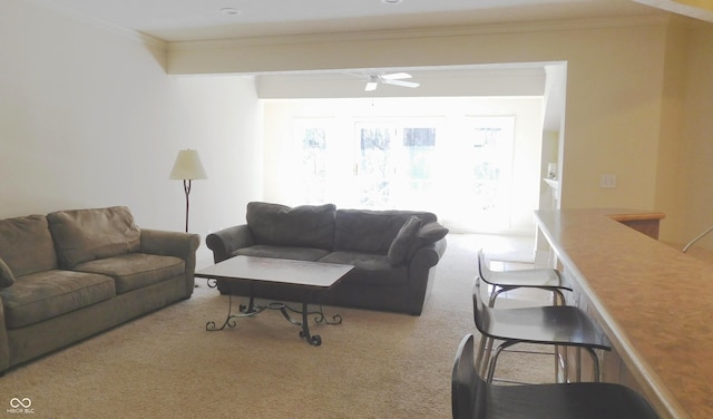 living room with carpet floors, ornamental molding, and ceiling fan