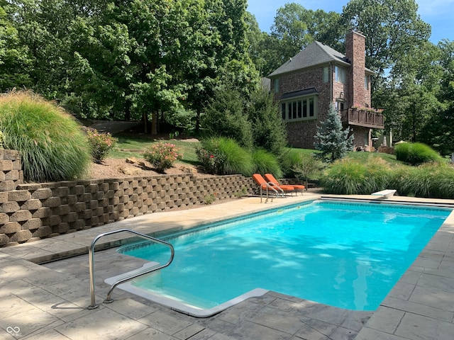 view of pool featuring a diving board and a patio area