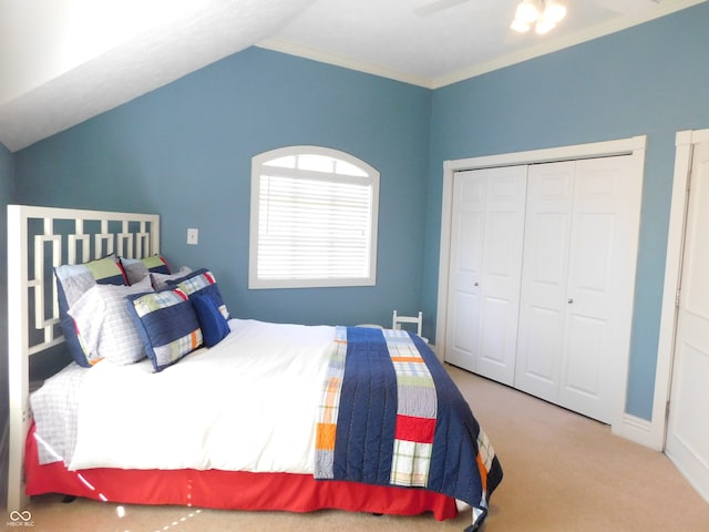 carpeted bedroom featuring ceiling fan, a closet, ornamental molding, and lofted ceiling