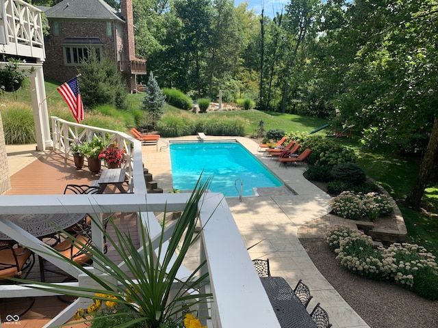 view of pool with a patio area and a diving board