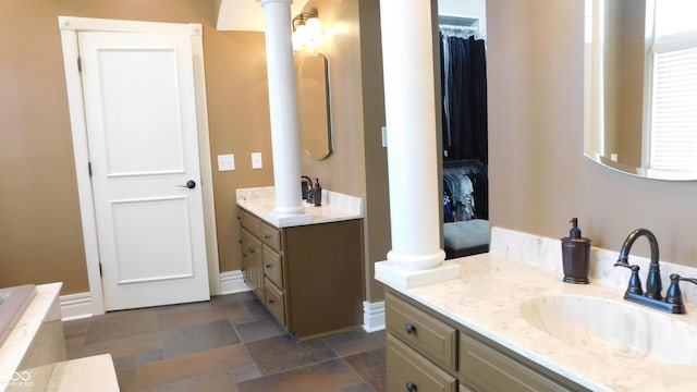 10781 Cedar Ridge Ln, Brownsburg, IN 46278 - full bath featuring baseboards, a sink, decorative columns, two vanities, and stone finish flooring