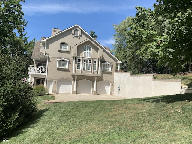 10781 Cedar Ridge Ln, Brownsburg, IN 46278 - rear view of house featuring a lawn, a balcony, a chimney, a garage, and driveway