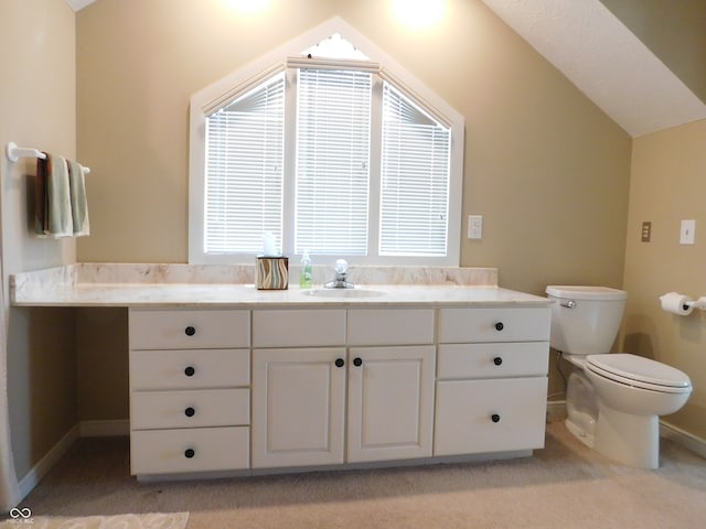 bathroom featuring vaulted ceiling, vanity, toilet, and a healthy amount of sunlight