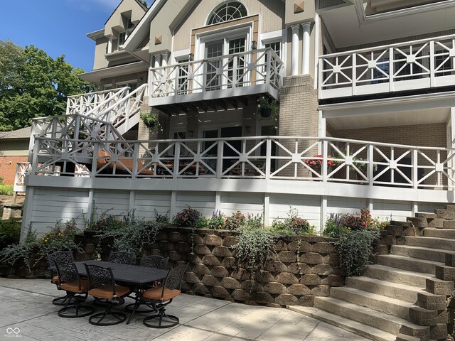 10781 Cedar Ridge Ln, Brownsburg, IN 46278 - back of house featuring a patio area, stairs, outdoor dining area, and brick siding