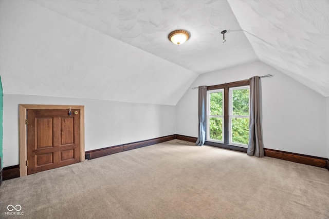 additional living space with light carpet and lofted ceiling