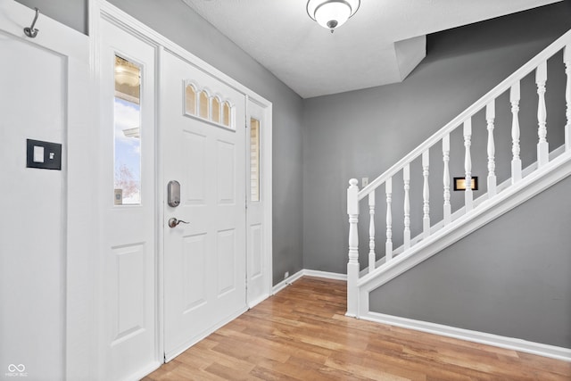 foyer with a textured ceiling and light wood-type flooring