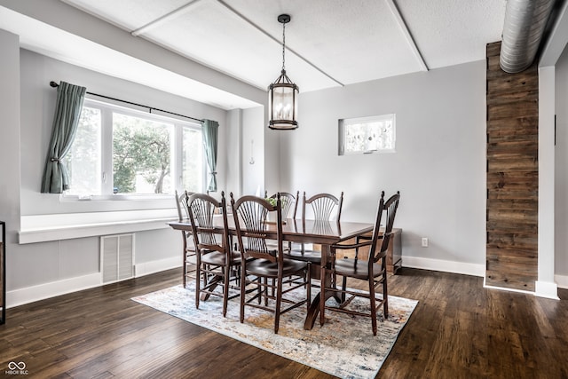 dining area featuring a notable chandelier and dark wood-type flooring