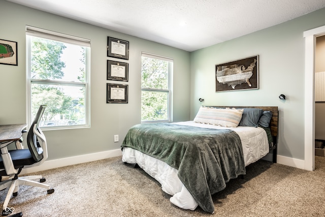 carpeted bedroom featuring a textured ceiling and multiple windows