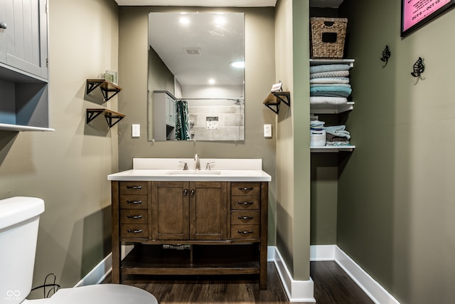 bathroom featuring curtained shower, hardwood / wood-style floors, vanity, and toilet