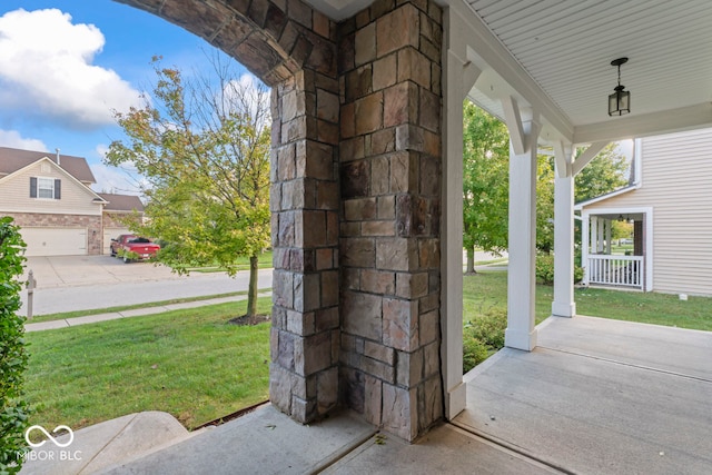 view of patio / terrace with a porch and a garage