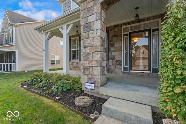 entrance to property featuring a yard and a porch