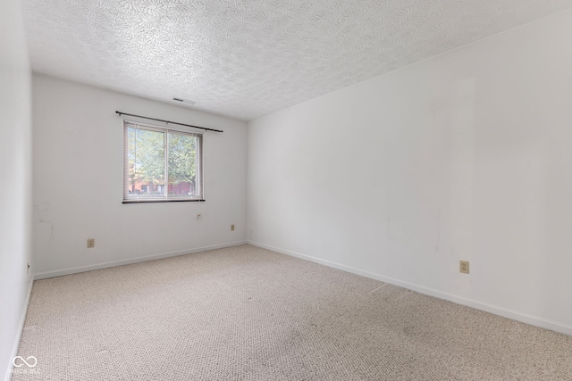 carpeted empty room featuring a textured ceiling