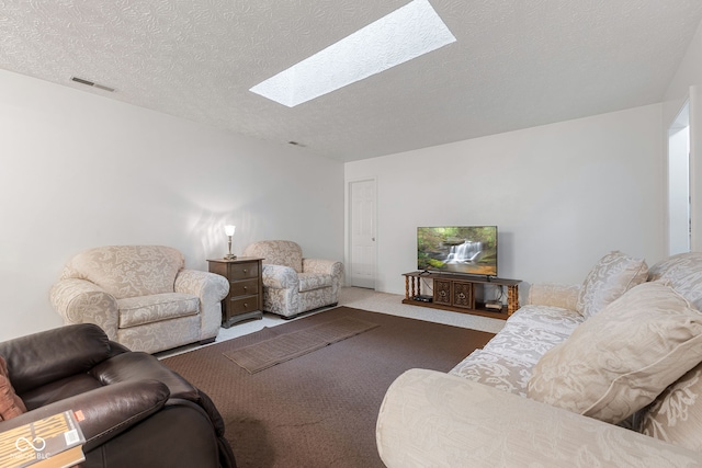 carpeted living room with a skylight and a textured ceiling