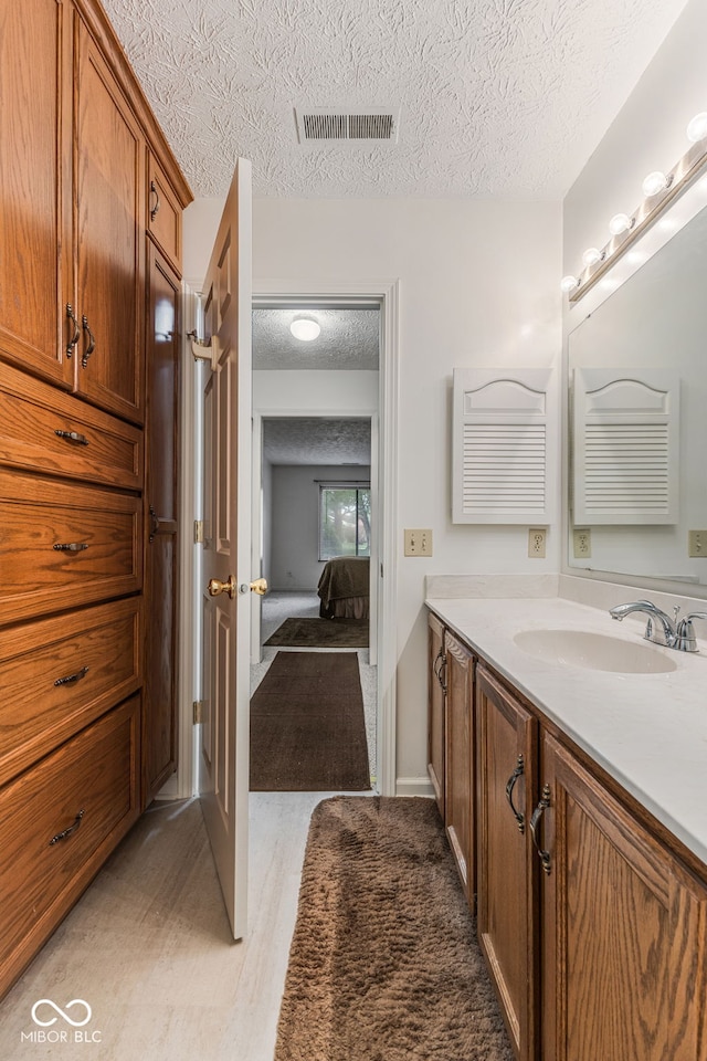 bathroom with wood-type flooring, a textured ceiling, and vanity