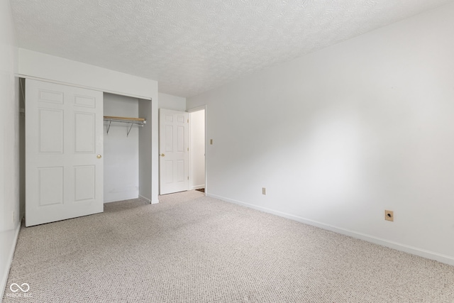 unfurnished bedroom with carpet, a closet, and a textured ceiling