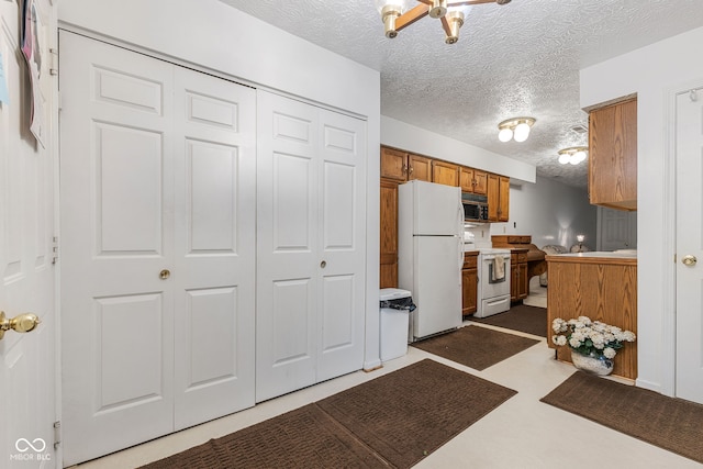 kitchen featuring a textured ceiling and white appliances