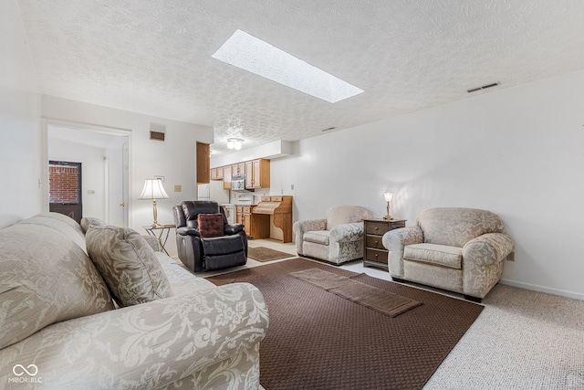 living room with a skylight, a textured ceiling, and carpet