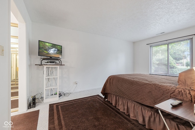 carpeted bedroom featuring a textured ceiling