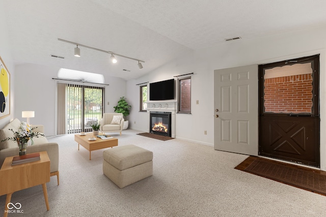 carpeted living room featuring lofted ceiling, a textured ceiling, and rail lighting