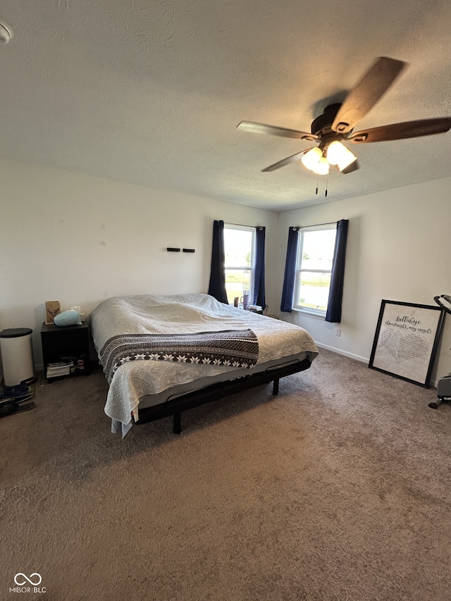 carpeted bedroom with ceiling fan and a textured ceiling