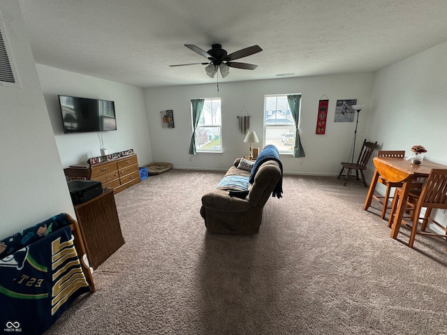 carpeted living room with a textured ceiling and ceiling fan