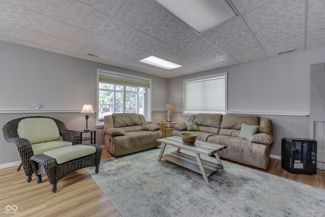 living room featuring a drop ceiling and hardwood / wood-style flooring