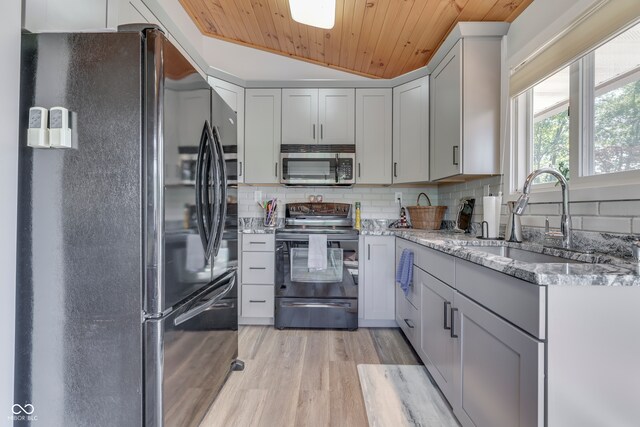 kitchen with sink, light hardwood / wood-style flooring, appliances with stainless steel finishes, wooden ceiling, and vaulted ceiling