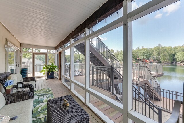 sunroom featuring a water view