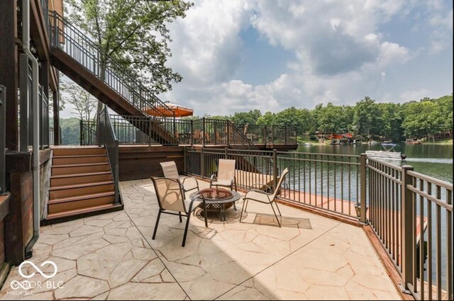 view of patio featuring a water view and a fire pit