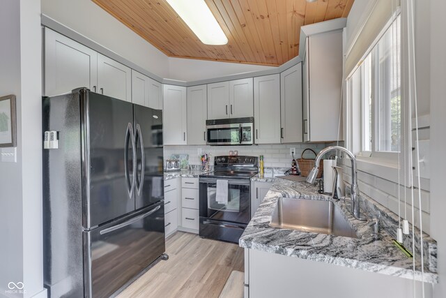 kitchen featuring wood ceiling, light hardwood / wood-style floors, sink, black appliances, and light stone countertops