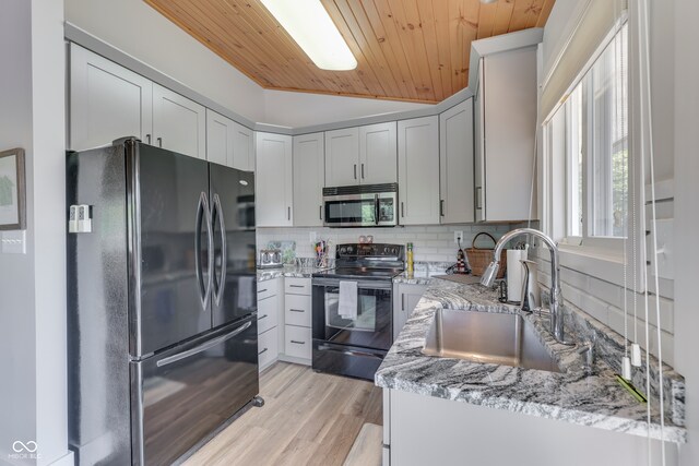 7438 Haw Dr, Nineveh, IN 46164 - kitchen featuring freestanding refrigerator, tasteful backsplash, stainless steel microwave, a sink, and black / electric stove