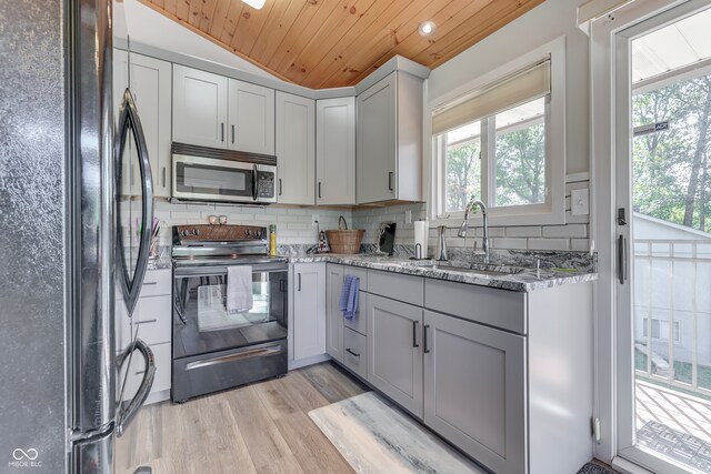 kitchen featuring black fridge, wood ceiling, sink, range with electric stovetop, and light hardwood / wood-style floors