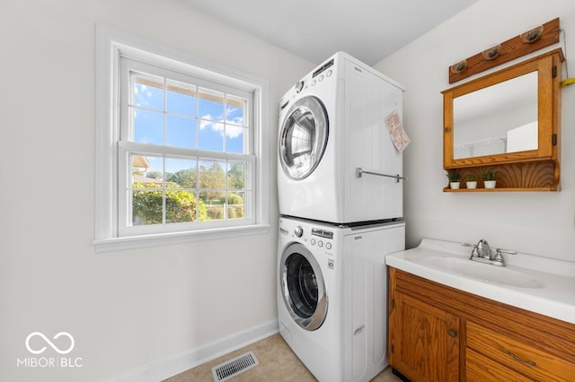 laundry room featuring sink and stacked washer / drying machine