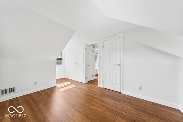 bonus room with hardwood / wood-style flooring and vaulted ceiling