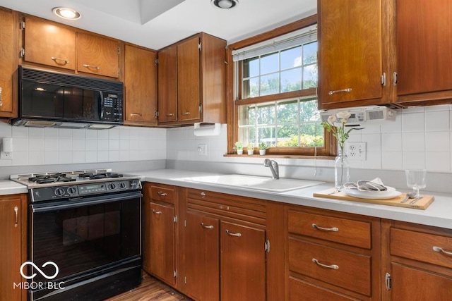 kitchen featuring backsplash, sink, and black appliances